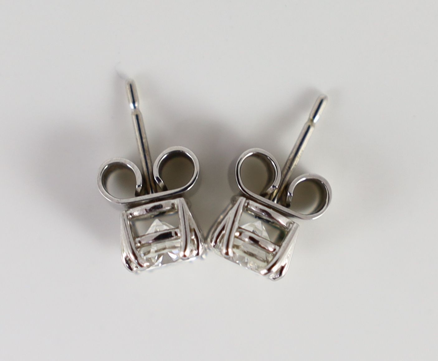 A pair of white gold and solitaire diamond set ear studs